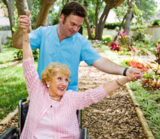 caregiver guiding senior woman to excercise